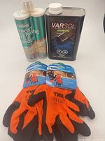 Group shot of all four items: two packaged glove pairs, Perflex grout cartridge, Varsol can