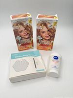 Group shot showing two Garnier hair dye boxes, Nivea anti-perspirant, nineblue silicone body scrubber box