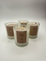 Four identical Rose Glow candles front view