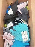 Box filled with assorted colour knit gloves with tags visible