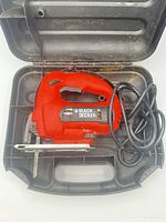 Jigsaw in open case showing tool, cord, blade