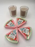 Group shot of two Rose Glow candles and four Beloved Watermelon & Mint Mojito bath bombs