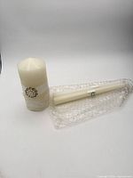 Pillar and one taper candle on bubble wrap