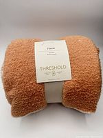 Folded throw blanket with label and strap