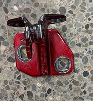 Upper hinge front view showing mounting plate, pivot and red paint