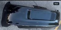 Top perspective of black Toyota Supra rear bumper showing overall shape and license plate recess