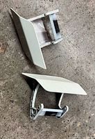 Two white headlight washer flaps shown front and back