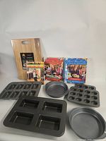 All items grouped: bakeware pieces, cutting board, three Pioneer Woman cookbooks