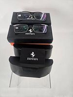 Two pairs of Ferrari frames with boxes, cases and accessories stacked