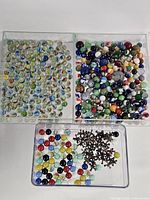 overview of three trays showing mixed marbles and jacks