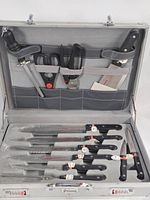 Set in open aluminium case showing all utensils in foam insert