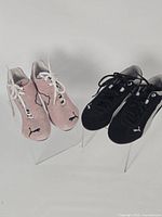 Both pairs of sneakers side by side on stands