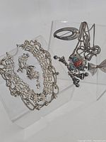 Group shot of all silver-tone jewelry pieces on clear stands