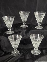 Five Waterford goblets arranged on black fabric