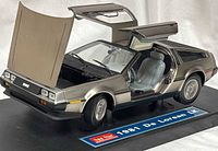 Model car with doors, hood and rear hatch open on display base