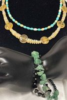 Two necklaces displayed on bust stand