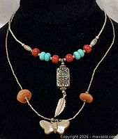 Close-up of both necklaces highlighting beadwork and pendants