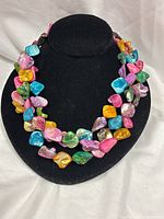 Necklace on display bust showing full three-strand design and multicolour shells