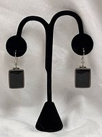 Full view of both earrings hanging on stand