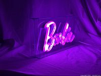 Barbie neon sign glowing pink inside acrylic case