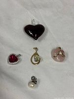 Group shot of all five pendants on white fabric background