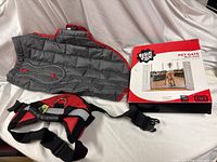 Grey quilted dog jacket, red-black harness, boxed pet gate