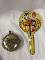 Front view showing tin noisemaker and pocket watch musical piece