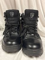 Front view of both boots showing toe caps, laces, and shield badges