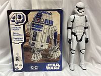 Front view showing boxed R2-D2 puzzle and Stormtrooper figure side by side