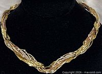 Close view of the twisted tri-metal necklace on display bust