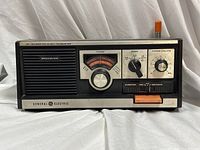 Front view showing speaker grill, controls, meter, and branding