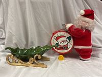 Santa figure with drum and ceramic sleigh bowl side by side