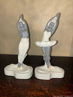 Both ballerina sculptures side by side showing size and design differences