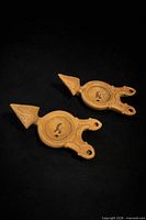 Top view of both clay oil lamps showing dual-wick spouts, handle, central fill holes