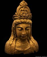 Front view of gilt wooden Buddha head showing facial features and crown