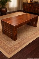 Full view of rectangular solid wood coffee table on rug