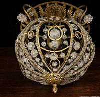 Full view of orb chandelier front, showing laurel crown and crystal drops