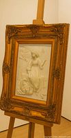 Front view of framed bas-relief on easel