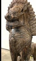 Full view of carved wooden guardian lion showing front and side details