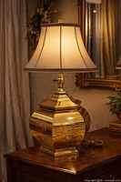 Full view of brass table lamp on wooden surface