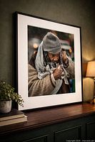 Framed photograph front view showing image of man with kitten, black frame, white mat