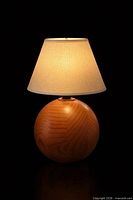 Front view of spherical solid wood lamp base with illustrative shade attached