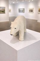 Front angled view of ceramic polar bear sculpture on plinth