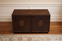 Front three-quarter view of cabinet showing overall form, finish and carved sunburst doors