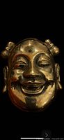 Front view of brass smiling sage mask
