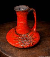 Front and side view of red earthenware jug on tabletop