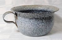 Side view of speckled enamel pot showing handle and overall form