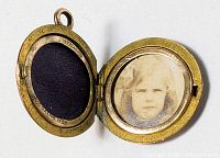 Locket open displaying sepia photograph, purple insert, rolled gold stamp
