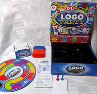 Complete Logo Party game set laid out with board, cards, timer, movers, instructions, box