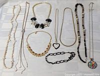 All ten necklaces arranged on flat surface showing full variety